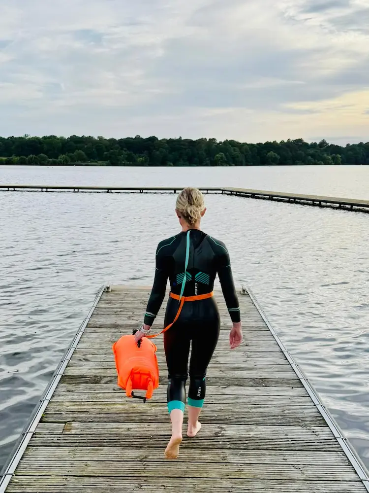 Woman heading into open water for an early morning swim